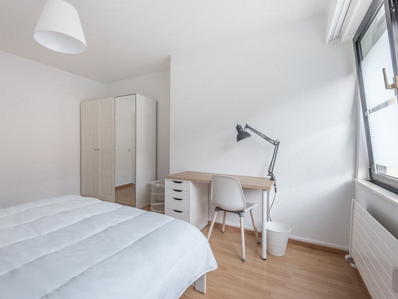 Coliving in Luxembourg city - furnished room with a double bed, bedside table, desk, chair, wardrobe.
