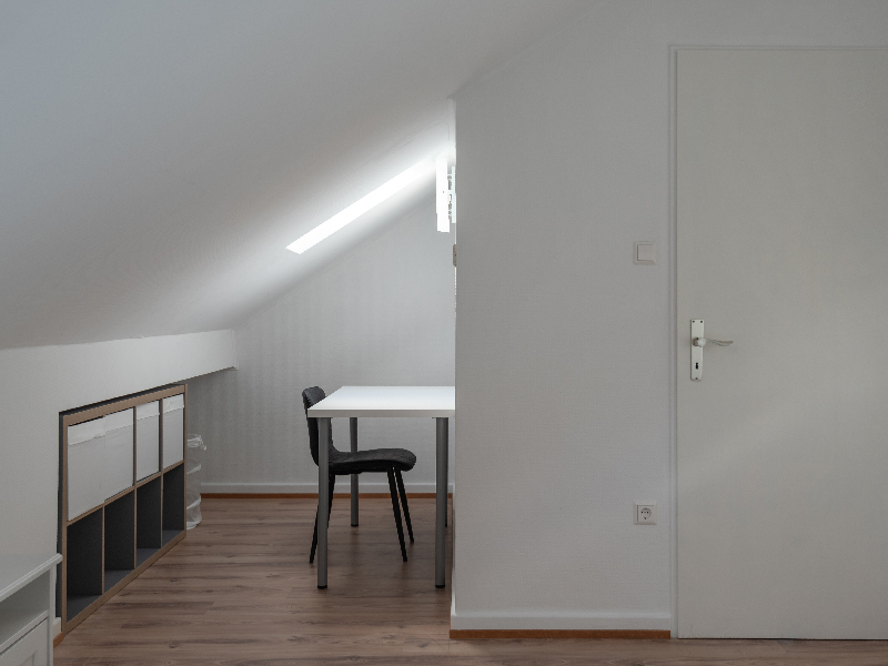Furnished room for rent in Luxembourg. The room includes a double bed, bedside table, wardrobe, desk and mirror.