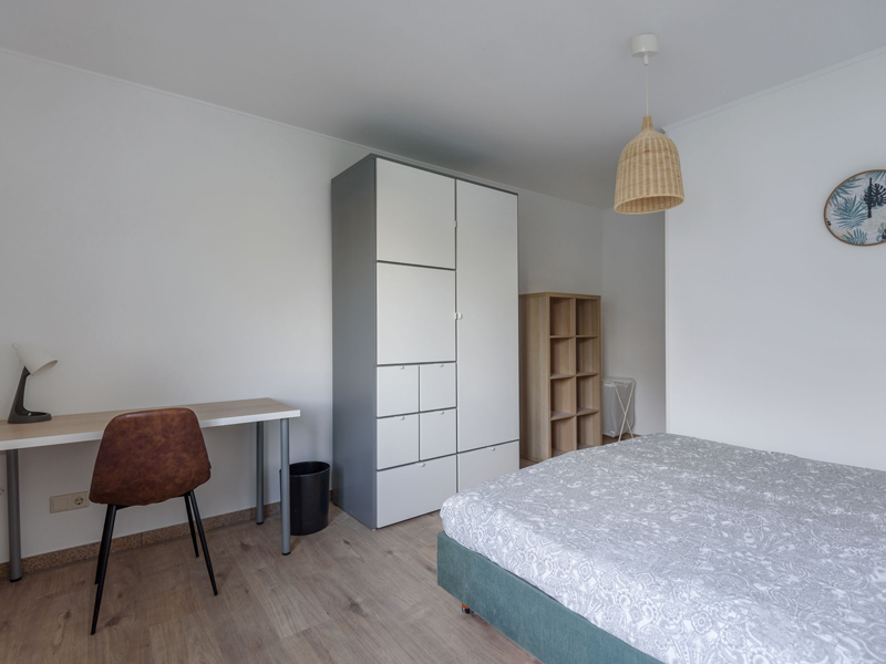 Furnished room for rent in coliving Luxembourg. It includes a double bed, bedside table, desk, chair, shelf, big wardrobe.
