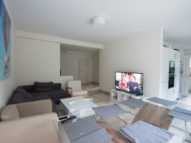 Luxembourg shared house living room interior with a dining table, sofa and TV