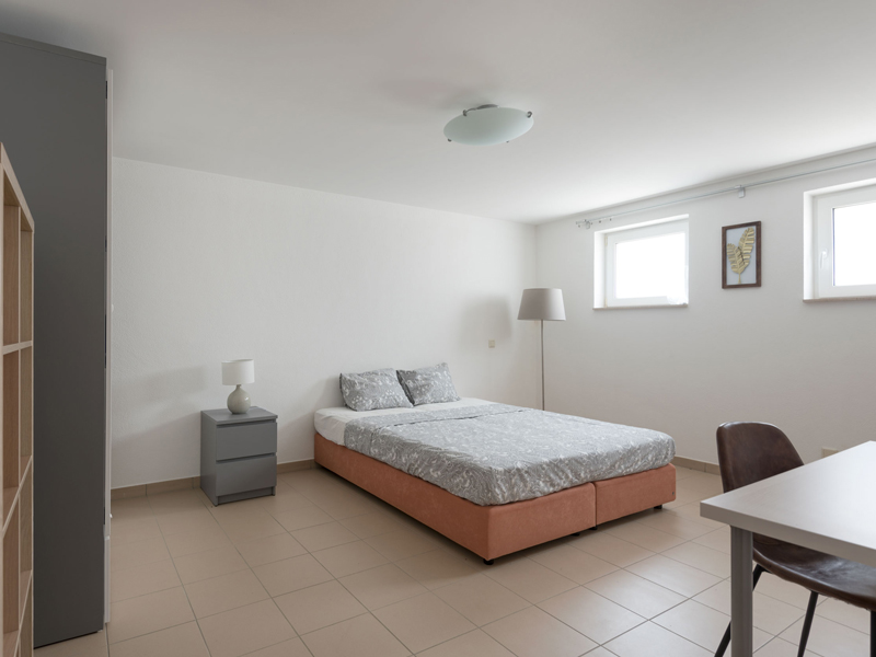 Room with private bathroom for rent Luxembourg. It includes double bed, bedside table, desk, chair
