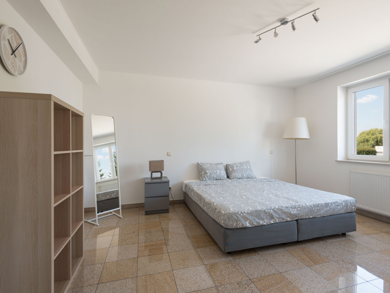 Furnished Room for Rent in Luxembourg. The room includes a double bed, bedside table, desk, chair, wardrobe, shelf.