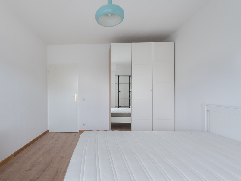 Furnished room for rent in Luxembourg City. The room includes a double bed, desk, chair, wardrobe and shelf.