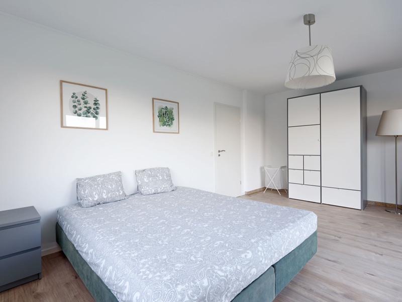 Furnished Room Luxembourg City. The room includes a double bed, bedside table, desk, chair, wardrobe, mirror and a shelf.