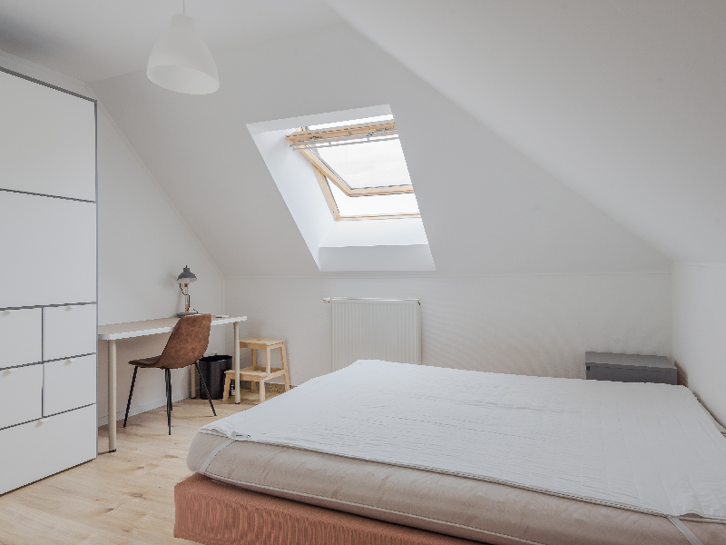 Furnished room for rent in Luxembourg. The room includes a double bed, bedside table, wardrobe, desk, mirror, shelf and a chair.